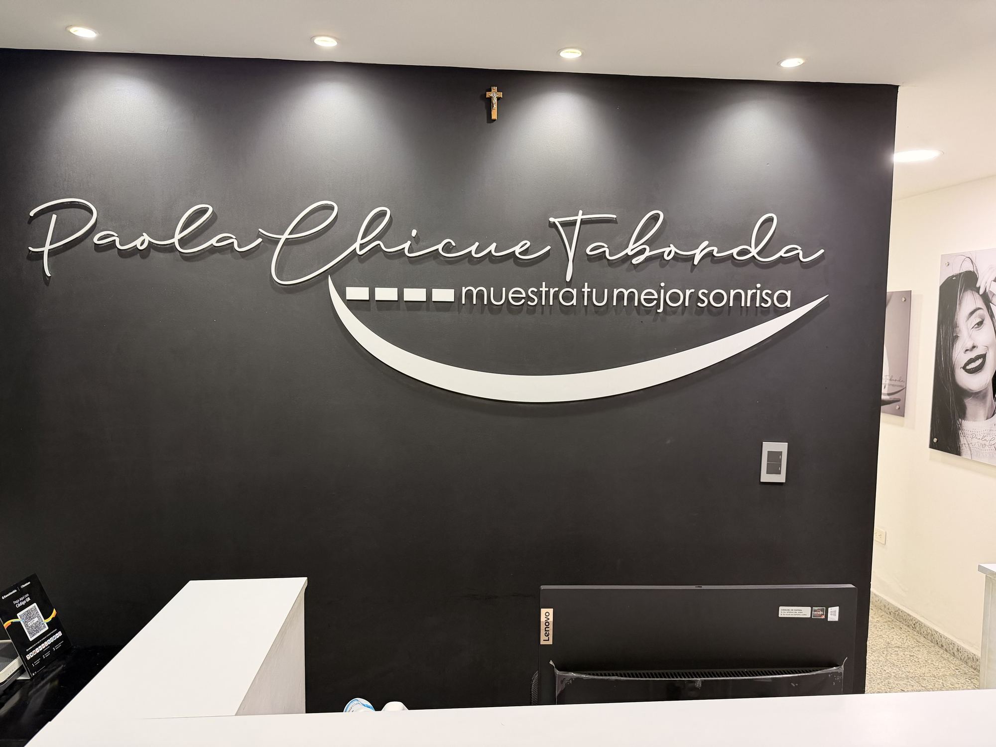 Reception of Dra. Paola Chicue Taborda's clinic in Cali, with her name on the black wall and the white front desk